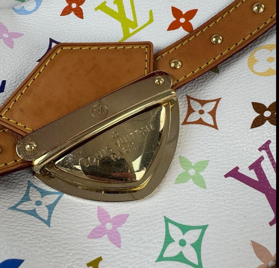 A Louis Vuitton belt with a polished gold-tone metal buckle and tan leather strap, laid flat on a white Louis Vuitton monogram canvas background.