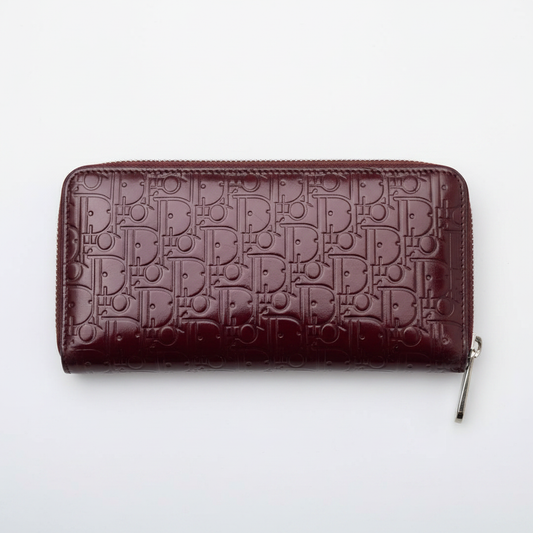 Christian Dior Oblique Zippy Wallet in burgundy patent leather, clean product shot