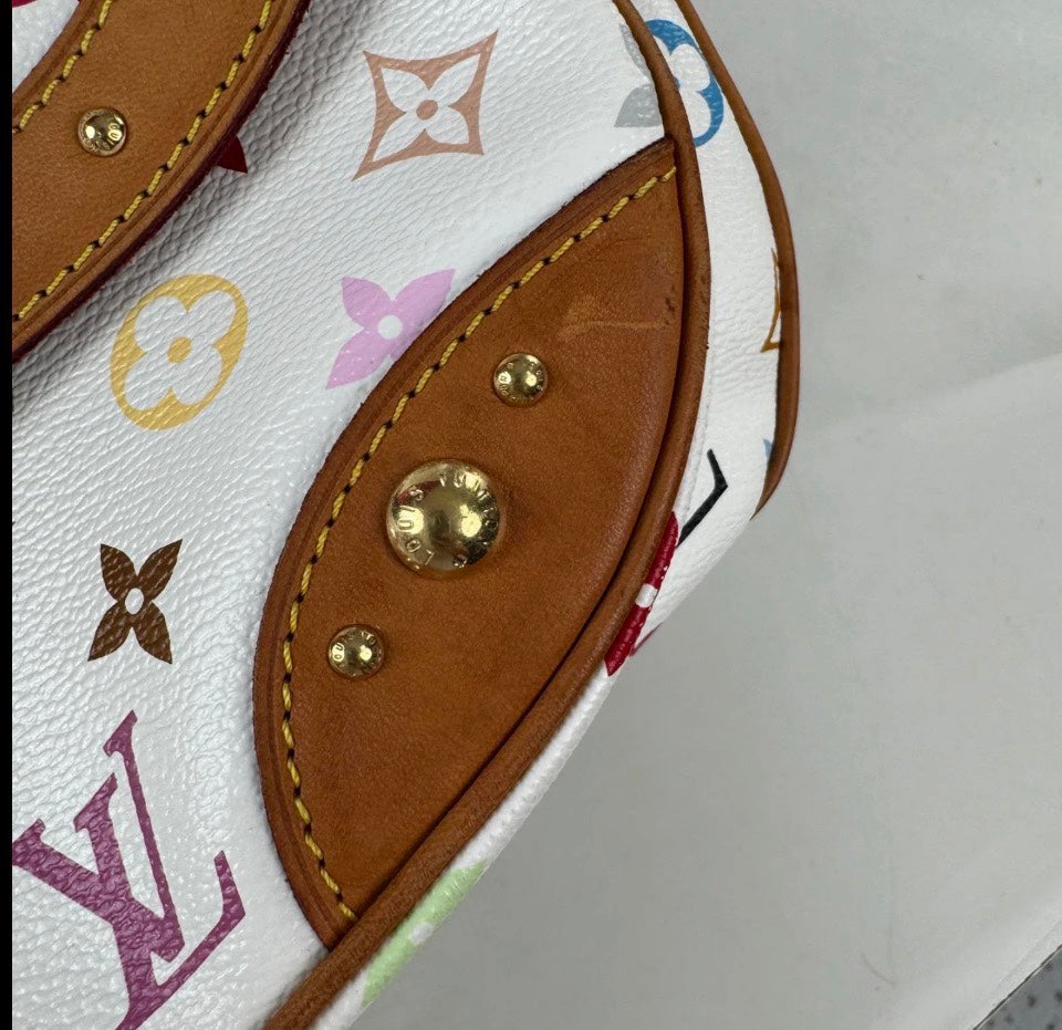 Close-up of a Louis Vuitton handbag featuring white coated canvas with multicolor monogram motifs, tan leather trim, and gold-tone metal studs.