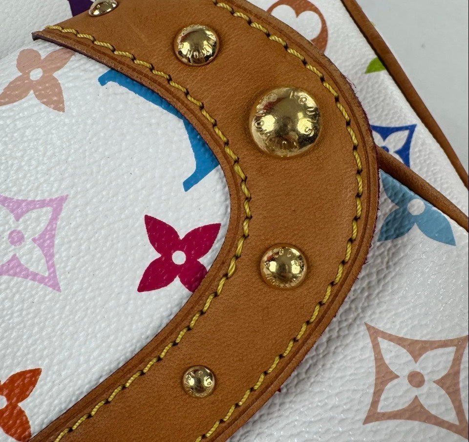 Close-up of a Louis Vuitton monogram canvas bag with a curved tan leather strap featuring gold-tone rivets and stitching over a white background with multicolored floral motifs.